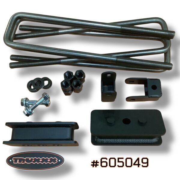 #605049 Detailed view of Truxxx heavy-duty 2-inch rear lift blocks and shock brackets for Ram 3500/4500/5500 DRW. Showcases the fully-welded 1/4-inch plate steel construction and durable black finish designed for emergency vehicle grade reliability and commercial use.
